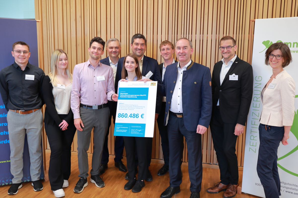 Wirtschaftsminister Aiwanger übergibt den Förderbescheid an das BAICert-Projektteam.